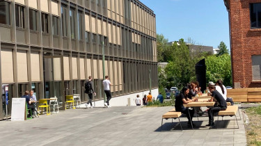Leute essen im sonnigen Außenbereich der Forschungskantine 