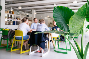 Eine Gruppe sitzt in der Forschungskantine mit aufgeklappten Laptops vor sich.