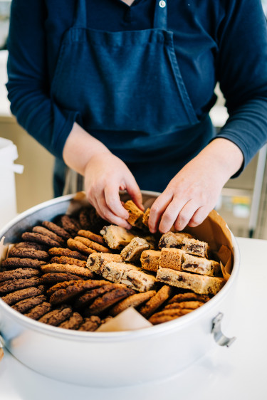 Eine Mitarbeiterin der Forschungskantine drapiert die frisch gebackenen Cookies  in der Auslage