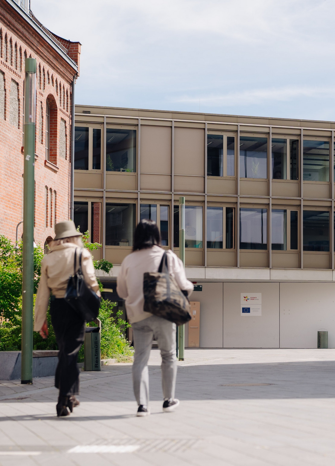 zwei Menschen gehen zum modernen Science Park Gebäude